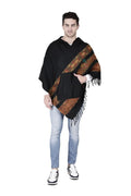 A man in light blue jeans, black and white sneakers, and an aruna kullu handloom kullu shawl woolen poncho with hood (black teen patti) stands facing forward against a white background.