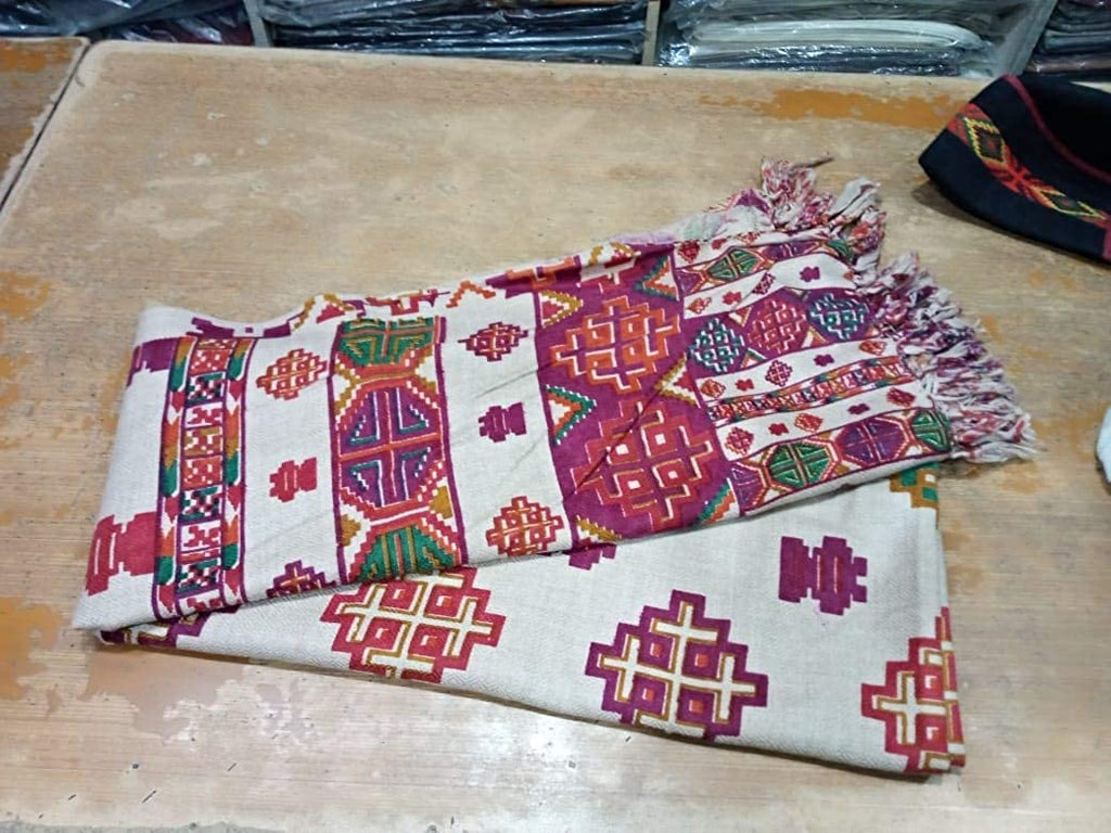 kinnauri shawl kullu and kinnauri shawls kinnauri shawls online kinnauri shawls history  A Pure Yak Wool Pashmina Kinnauri Triple Border printed shawl by aruna kullu handloom, inspired by traditional designs, displayed on a table.