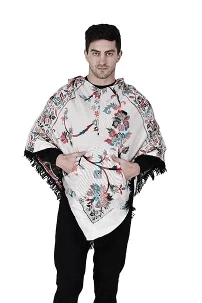 A man with short dark hair models the aruna kullu handloom Shimla jacket price kullu shawl woolen poncho with hood kashmiri silver over a black outfit, standing against a white background.Pahadi poncho for men pahadi kullu poncho mens kullu woolen poncho himachali poncho for men Himachali poncho online
