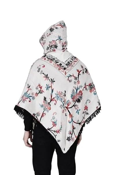 A man with short dark hair models the aruna kullu handloom Shimla jacket price kullu shawl woolen poncho with hood kashmiri silver over a black outfit, standing against a white background.Pahadi poncho for men pahadi kullu poncho mens kullu woolen poncho himachali poncho for men Himachali poncho online