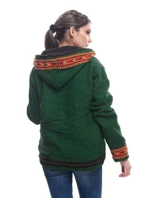 A person with brown hair in a ponytail wears an aruna kullu handloom green ZIPPER HOODIE Jacket for MEN & Women with kullu patti work, paired with blue jeans, standing back to the camera against a white background.kullu patti hoodies online kullu patti hoodies kullu hoodie woolen kullu woolen hoodies kullu hoodie for girls