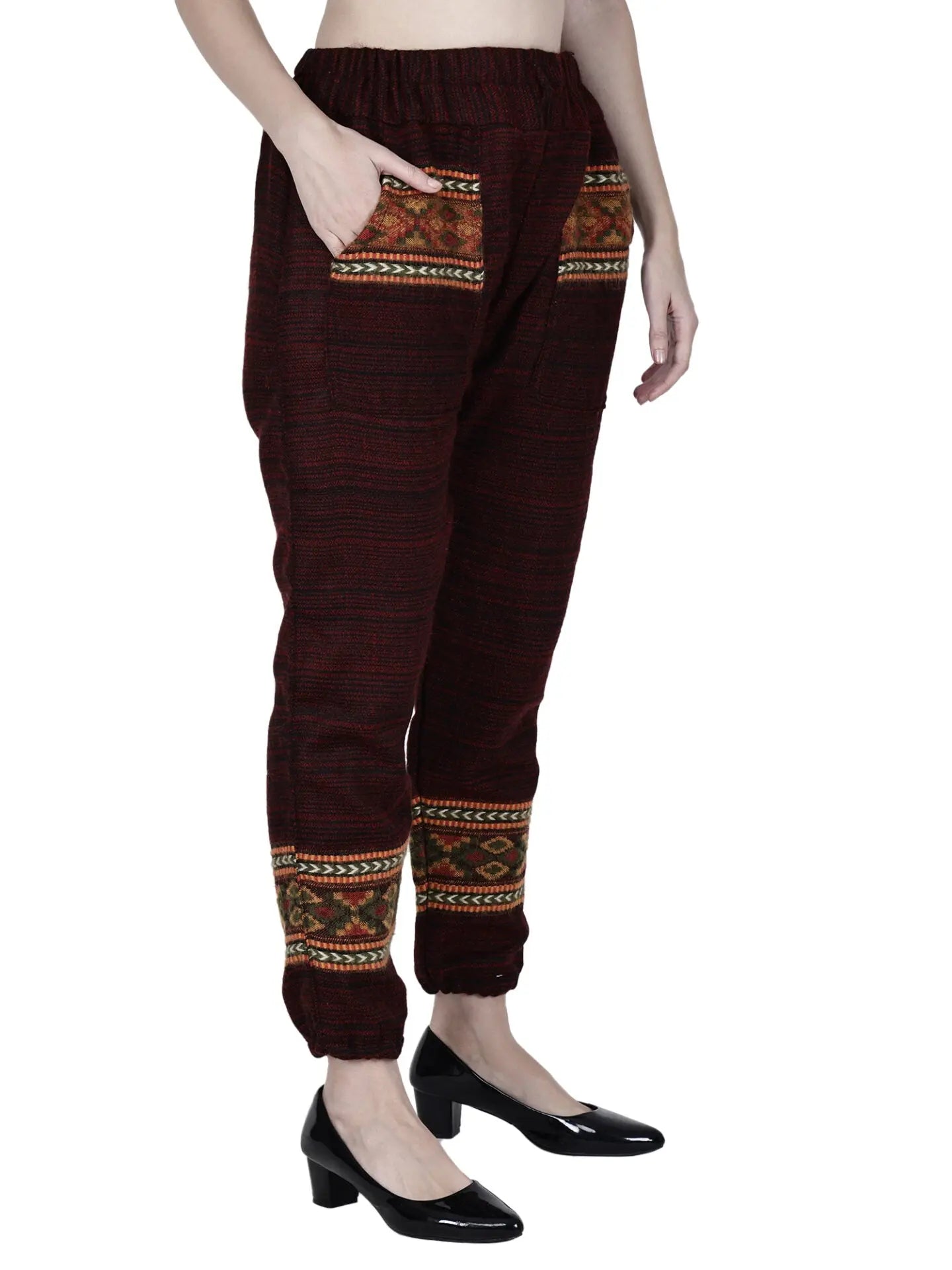 A person wears the aruna kullu handloom woolen pajama for ladies in maroon with ethnic-patterned pockets and ankle detailing, paired with black low-heeled shoes; upper body is partially out of frame.