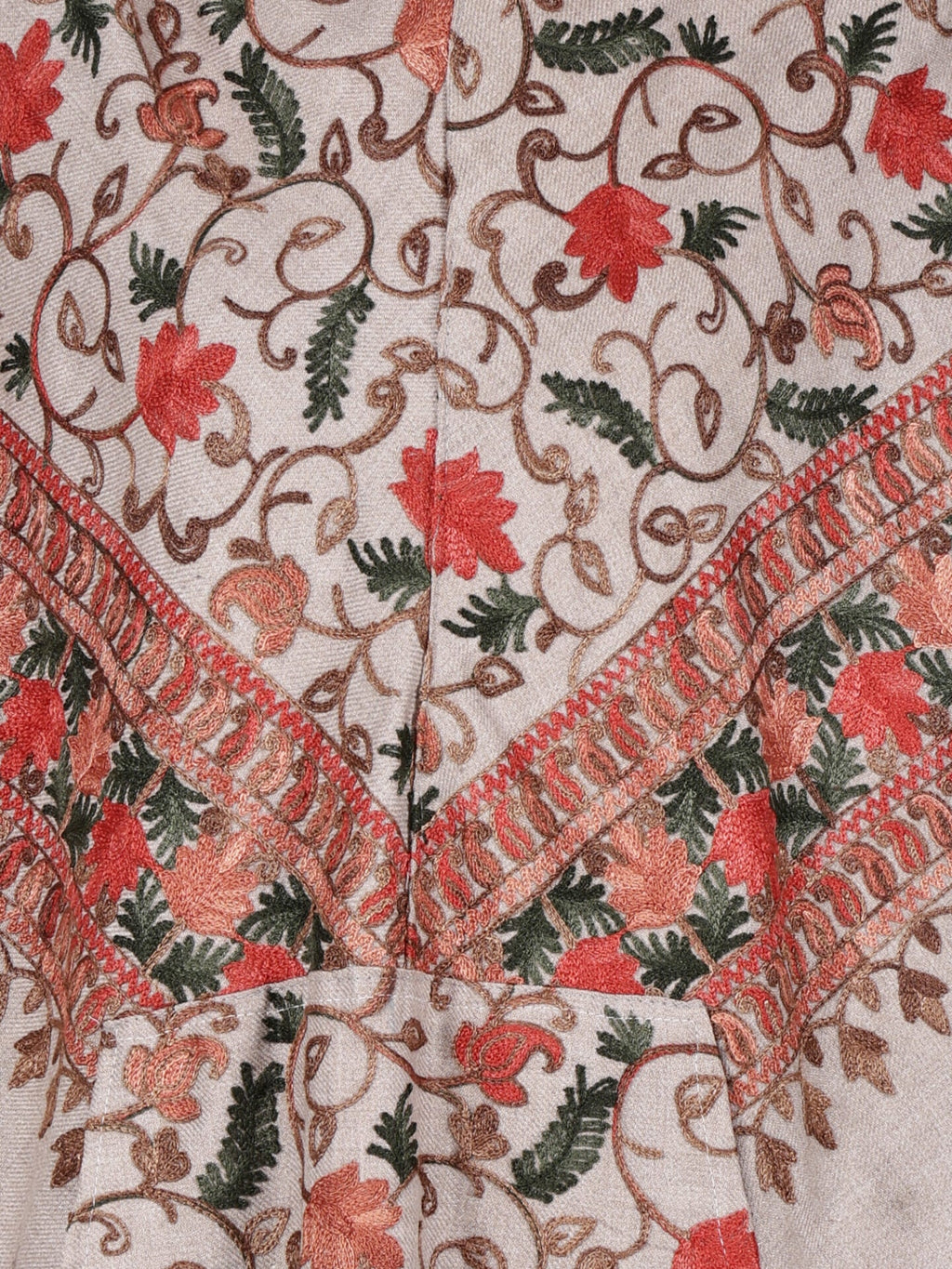 The aruna kullu handloom poncho sweater is an off white Kashmiri embroidered woolen poncho for ladies, featuring intricate red and green floral and leafy patterns, vines, a decorative border, and a hood.