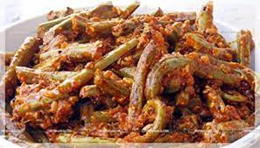 A close-up of Lingdu Ka Achar by aruna kullu handloom, featuring fiddlehead ferns (Kasrod) coated in a rich, reddish-brown spice and tomato mix, capturing the vibrant flavors of traditional Kasrod Ka Achar.