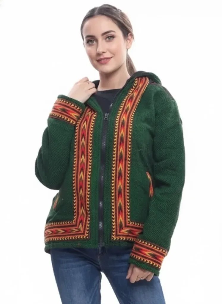 A woman smiles in an aruna kullu handloom green ZIPPER HOODIE jacket for men & women, featuring colorful kullu patti work on the front, cuffs, and hem. She pairs it with blue jeans and stands against a white background.kullu patti hoodies online kullu patti hoodies kullu hoodie woolen kullu woolen hoodies kullu hoodie for girls